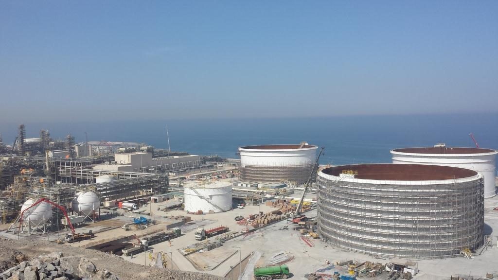 Aerial view of storage tanks under construction beside the sea.